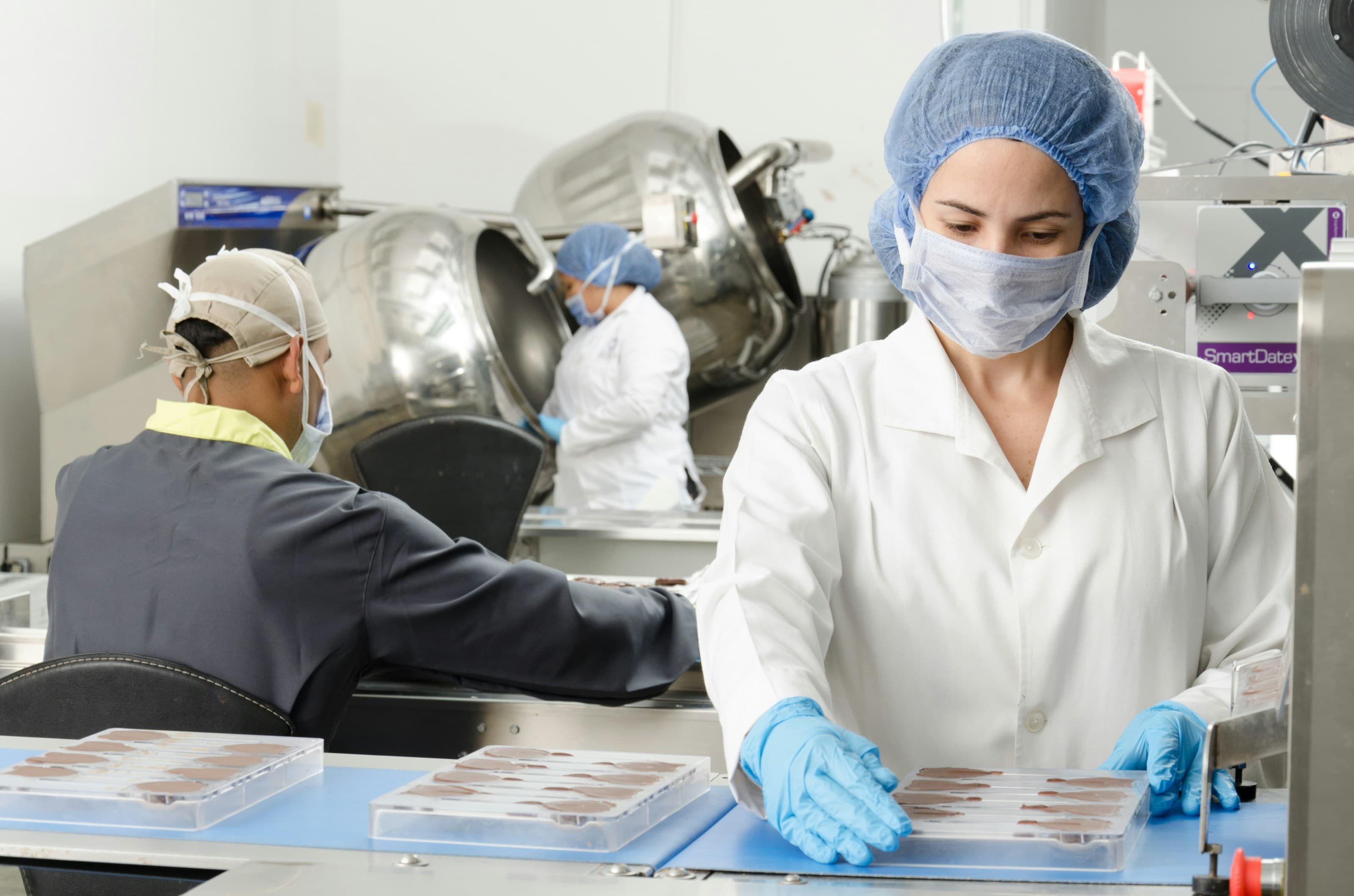 Production professionals working in a controlled manufacturing environment