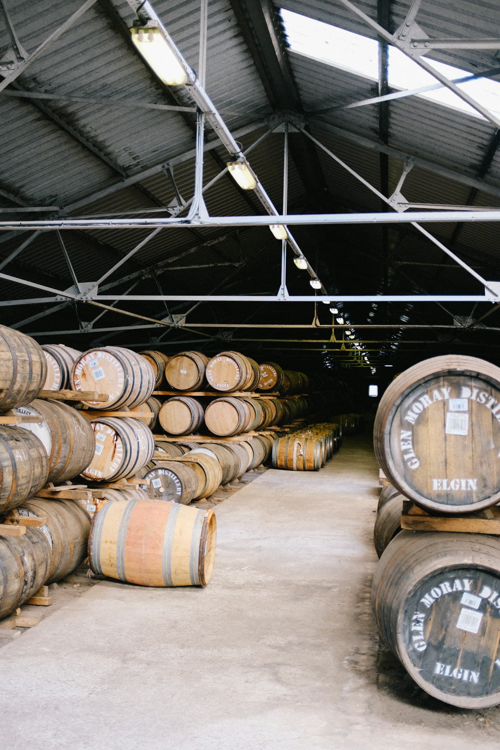 Industrial warehouse with stored barrels and equipment.